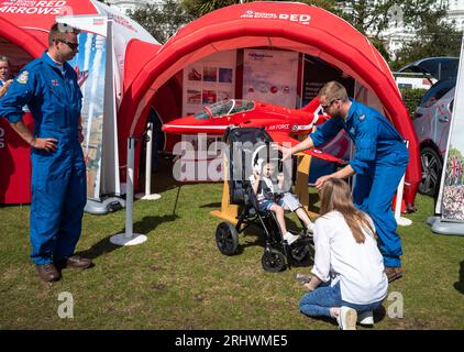 Eastbourne, Großbritannien. August 2023. Ein kleines Kind in einem Schubkarren versucht auf dem Red Arrows Ausstellungsstand in der Militärausstellung neben der jährlichen Eastbourne Airbourne, einer internationalen Flugschau, einen RAF-Flughelm zu tragen. Die Show findet vier Tage lang statt, mit Flugvorführungen entlang der Küste. Andy Soloman/Alamy Live News Stockfoto