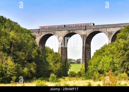 Barry, Wales – 17. August 2023: Pendlerzug von Transport for Wales, der das Steinviadukt über Porthkerry Country Psrk in Südwales überquert Stockfoto