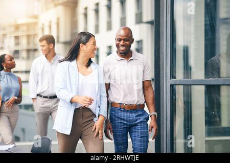 Zufriedene Mitarbeiter und zu Fuß in das Arbeitsgebäude in Atlanta, in die Stadt und in das städtische Firmenbüro oder am Morgen auf dem Weg zur Arbeit. Social Media, Konversation und Stockfoto