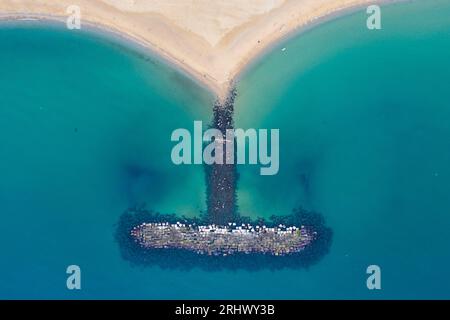 Blick aus der Vogelperspektive auf den Strand und den Steindeich an der Küste von Barceloneta Beach, Barcelona, Spanien Stockfoto