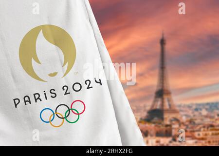 Antalya, Türkei - 18. August 2023: Flagge der Olympischen Spiele 2024 in Paris vor der verschwommenen Skyline von Paris Stockfoto