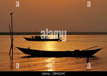 Traditionelle Boote sind im Fluss Padma während der Sonnenuntergangszeit Stockfoto