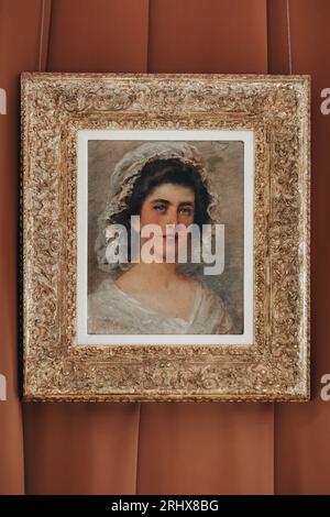 Malporträt einer Frau in einem an der Wand hängenden vergoldeten Rahmen. Historische Details im Inneren des Museums Stockfoto