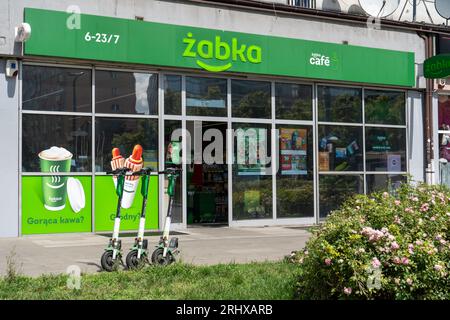 Schild des polnischen Lebensmittelgeschäfts ZABKA Cafe. Supermarkt mit grünem Schild. Hausfassade. Straßengeschäft. Warschau, Polen - 26. Juli 2023. Stockfoto