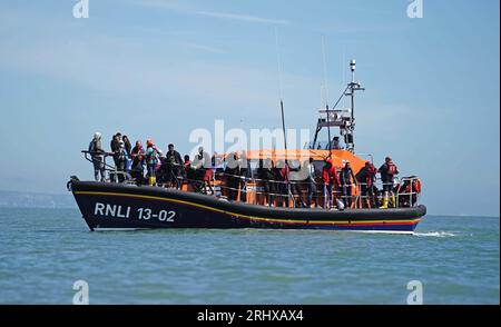 Aktenfoto vom 8/2023 einer Gruppe von Menschen, die als Migranten gelten, werden nach einem kleinen Bootvorfall im Ärmelkanal nach Dungeness, Kent, an Bord eines RNLI Dungeness Lifeboats gebracht. Mehr als 25.000 Asylbewerber sind nach Angaben der Labour Party mit kleinen Booten nach Großbritannien gekommen, seit Rishi Sunak Premierminister wurde. Ausgabedatum: Samstag, 19. August 2023. Stockfoto