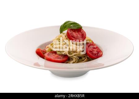 Linguine von zwei Arten, weiß und grün, mit frischen Tomatenscheiben, Basilikumblättern und Olivenöl in einem Gericht isoliert auf weiß mit Schnittpfad Stockfoto