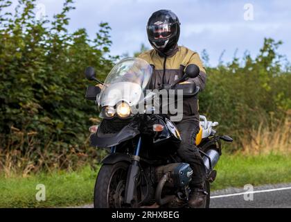 Woburn, Beds, UK - 19. August 2023: Mann fährt ein BMW Motorrad auf einer englischen Landstraße. Stockfoto