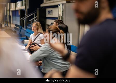 Eine große Gruppe von Studierenden versammelte sich am Tisch im Universitätshof, teilte Wissen und bereitete die Prüfung gemeinsam vor Stockfoto