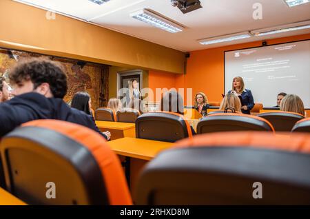 Gruppe von Studenten und Professoren, die sich darauf vorbereiten, von ihren Schülern ein Projekt präsentieren zu hören Stockfoto