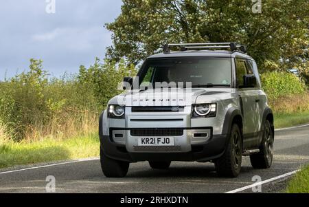 Woburn, Beds, Großbritannien - 19. August 2023: Silbernes Land Rover Defender-Auto 2021, das auf einer englischen Landstraße fährt. Stockfoto