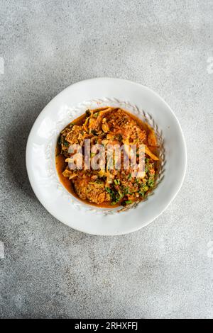 Blick auf das georgianische Gupta-Gericht mit Fleischbällchen und Reis in Tomatensauce mit Kohl, Karotte und Zwiebeln, serviert mit geschnittener coria auf dem Teller Stockfoto