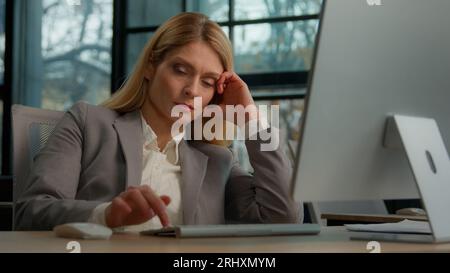 Müde faule traurige Erwachsene Frauen mittleren Alters weibliche Manager Angestellte langweilig bei der Arbeit Projekt online in Computer im Büro Kaukasier erschöpft Reifen Stockfoto