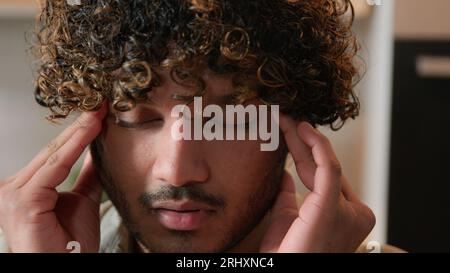 Nahaufnahme Kranke müde arabische männliche Massage Schläfen schmerzhafte Kopf Migräne Druck Kopfschmerz zu Hause Küche. Der Indianer leidet unter Kopfschmerzen. Ill Stockfoto