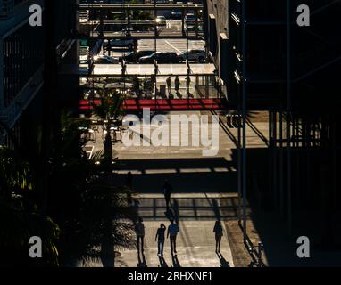 Urbane Fußgänger, die am Nachmittag lange Schatten werfen, abstrakte Silhouettenansicht mit hohem Winkel Stockfoto