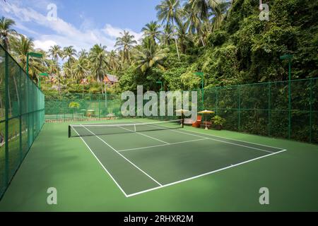 Phuket, Thailand - 1. Dezember 2018: Tennisplatz im Freien im luxuriösen Amanpuri Resort Hotel in Phuket, Thailand. Stockfoto