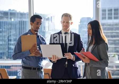 Internationale, vielfältige Business-Team-Mitarbeiter, die im Büro mit einem Laptop arbeiten. Stockfoto