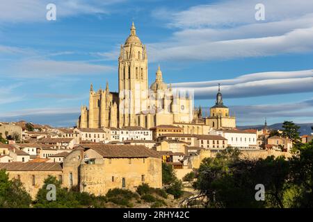 Segovia, Spanien, Stadtbild mit Segovia Kathedrale an der Spitze, Kirchturm und mittelalterliche Architektur rund um, Lentikularwolken am Himmel. Stockfoto