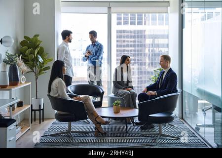 Geschäftige Geschäftsleute mit professionellem Team sprechen in der Bürolobby. Authentische Aufnahme Stockfoto