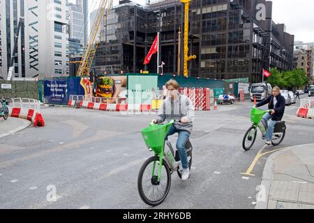 Sehen Sie Radfahrer Lime Bikes Wilson & Sun Streets Broadgate Gebäude Abbruchstelle Kräne Gerüste in der City of London EC2 2023 England UK KATHY DEWITT Stockfoto