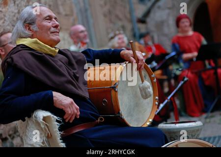 19. August 2023, Sachsen-Anhalt, Falkenstein/Harz: Musiker lauschen den mittelalterlichen Klängen der Minstrel beim 16. Falkenstein Minstrel-Turnier unter dem Motto „unter dem Zauber der Antike“. Künstler aus ganz Deutschland singen Lieder und erzählen Geschichten über König Arthur und seinen Tafelrunde, Siegfried und Kriemhild, Tristan und Isolde, Hildebrand und Hadubrand. Es gab auch ein mittelalterliches episches Gedicht, das auf einem biblischen Modell basierte. Foto: Matthias Bein/dpa/ZB Stockfoto