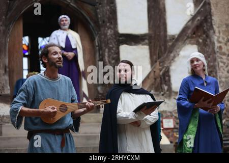 19. August 2023, Sachsen-Anhalt, Falkenstein/Harz: Minstrel Michael Eberle (M) tritt beim 16. Falkenstein Minstrel Turnier auf und singt die Evangelienharmonie unter dem Motto „unter dem Zauber der Antiken“. Künstler aus ganz Deutschland singen Lieder und erzählen Geschichten über König Arthur und seine Tafelrunde, Siegfried und Kriemhild, Tristan und Isolde, Hildebrand und Hadubrand. Es gab auch ein mittelalterliches episches Gedicht, das auf einem biblischen Modell basierte. Foto: Matthias Bein/dpa/ZB Stockfoto