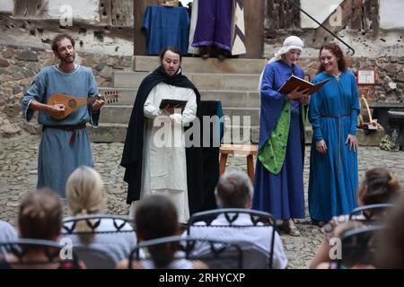 19. August 2023, Sachsen-Anhalt, Falkenstein/Harz: Der Minstrel Michael Eberle (2. V.l.) tritt beim 16. Falkenstein Minstrel Tournament auf und singt die Evangelienharmonie unter dem Motto „Under the Spell of the Ancient Epics“. Künstler aus ganz Deutschland singen Lieder und erzählen Geschichten über König Arthur und seine Tafelrunde, Siegfried und Kriemhild, Tristan und Isolde, Hildebrand und Hadubrand. Es gab auch ein mittelalterliches episches Gedicht, das auf einem biblischen Modell basierte. Foto: Matthias Bein/dpa/ZB Stockfoto