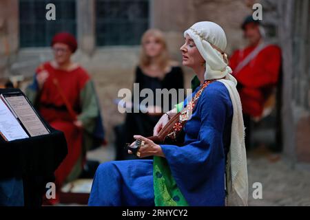 19. August 2023, Sachsen-Anhalt, Falkenstein/Harz: Christine Zienc-Tomczak gewann das 16. Falkensteiner Minneturnier auf Schloss Falkenstein. Unter dem Motto „Under the spell of the ancient Epics“ sangen Künstler aus ganz Deutschland Lieder und erzählten Geschichten über König Arthur und seinen Tafelrunden, Siegfried und Kriemhild, Tristan und Isolde, Hildebrand und Hadubrand. Es gab auch ein mittelalterliches episches Gedicht, das auf einem biblischen Modell basierte. Foto: Matthias Bein/dpa/ZB Stockfoto