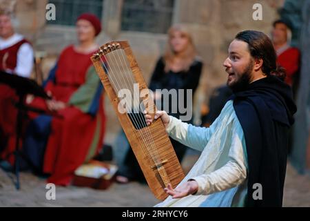 19. August 2023, Sachsen-Anhalt, Falkenstein/Harz: Der Minstrel Michael Eberle tritt beim 16. Falkenstein-Minstrel-Turnier auf und singt die Evangelienharmonie unter dem Motto „unter dem Zauber der Antiken“. Künstler aus ganz Deutschland singen Lieder und erzählen Geschichten über König Arthur und seine Tafelrunde, Siegfried und Kriemhild, Tristan und Isolde, Hildebrand und Hadubrand. Es gab auch ein mittelalterliches episches Gedicht, das auf einem biblischen Modell basierte. Foto: Matthias Bein/dpa/ZB Stockfoto