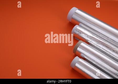 Rollen aus Aluminiumfolie auf rotem Hintergrund, Nahaufnahme. Leerzeichen für Text Stockfoto