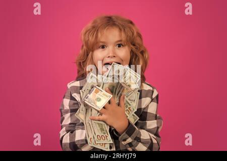 Der Junge hat viele hundert Dollar isoliert auf rosa rotem Hintergrund. Stockfoto
