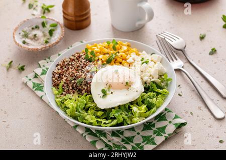 Frühstücksschale mit Quinoa, Kräutermais, Feta-Käse und Spiegelei Stockfoto