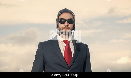 Porträt des Geschäftsmannes in Anzug und Pilotenhut auf Himmel Hintergrund Stockfoto