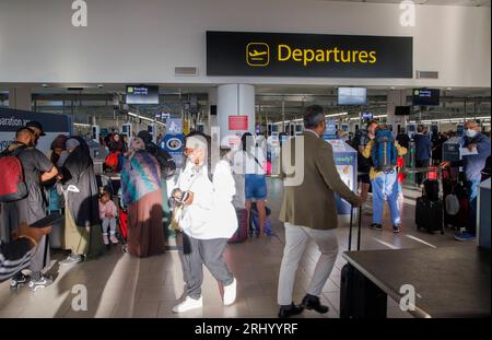 Passagiere am Abflugsteig am Flughafen Gatwick. Urlauber, die Sicherheitskontrollen durchlaufen. Stockfoto