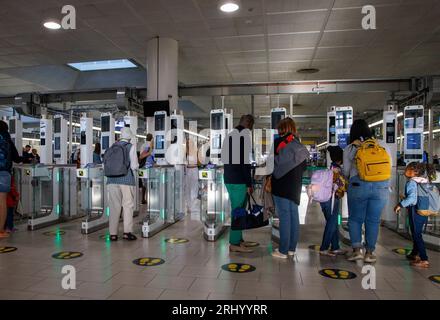 Passagiere am Abflugsteig am Flughafen Gatwick. Urlauber, die Sicherheitskontrollen durchlaufen. Stockfoto