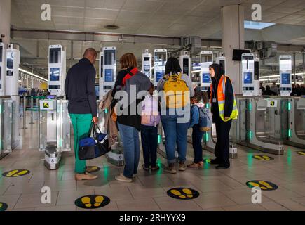 Passagiere am Abflugsteig am Flughafen Gatwick. Urlauber, die Sicherheitskontrollen durchlaufen. Stockfoto