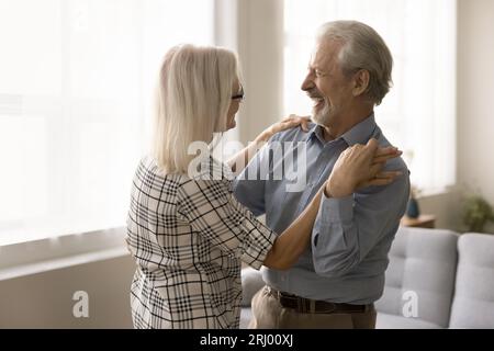 Glückliches Seniorenpaar, das zu Hause sozialen Tanz trainiert und Musik genießt Stockfoto