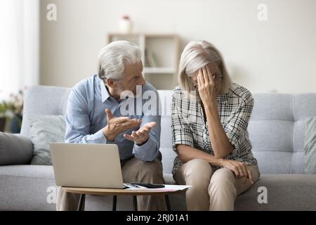 Frustriertes älteres Paar, das über finanzielle Probleme am Laptop streitet Stockfoto
