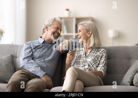 Fröhliches älteres Ehepaar, das zu Hause auf dem Sofa ruht Stockfoto