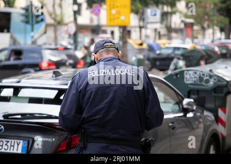 Mailand, Italien - 08 17 2023 : Polizia örtlicher Polizist italien Polizei lokales Hemd mit Textschild Polizei hinter Rückansicht der italienischen Polizei in der Straße Stockfoto