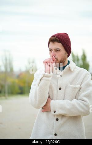 Lateinischer junger Mann hustet im Winter, Grippe. Stockfoto