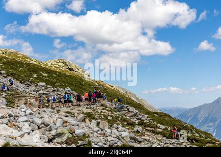 Österreich. August 2023. Auf einem Wanderweg in den Zillertaler Alpen warten Menschen an einer Hängebrücke auf, um sich fotografieren zu lassen. Das Bild der Hängebrücke mit dem atemberaubenden Blick auf den Schlegeis-Stausee und die umliegenden Alpengipfel ist ein sehr beliebtes Fotomotiv in Online-Medien. Viele Menschen machen den Aufstieg vom Schlegeis-Speicher (1782 m) zur Olpererhütte (2389 m) nur für ein Foto wie dieses. Quelle: Frank Hammerschmidt/dpa/Alamy Live News Stockfoto