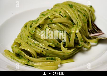 Trenette oder Linguine Pasta mit grünem Pesto alla Genovese mit Basilikum Stockfoto