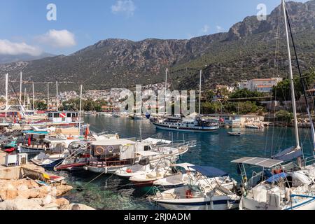 Ein türkischer Gulet, der im Hafen von Kas ankommt, der von Booten gesäumt ist. Kas ist eine Küstenstadt an der Mittelmeerküste im Südwesten der Türkei. Stockfoto