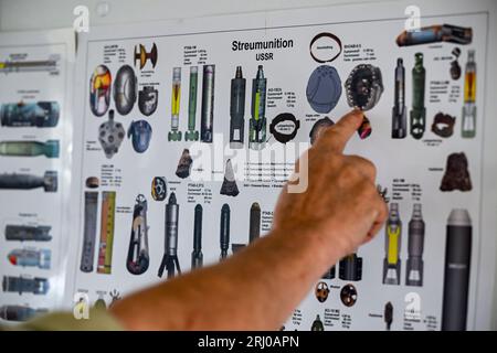 Neuglienicke, Deutschland. August 2023. Ein Überblick über russische Streumunition hängt in einem Büro auf dem ehemaligen militärischen Trainingsgelände in Kyritz-Ruppiner Heide. Hier werden Sprengkörper aus dem ehemaligen Bombodrom geborgen, insbesondere Streumunition. Quelle: Jens Kalaene/dpa/Alamy Live News Stockfoto