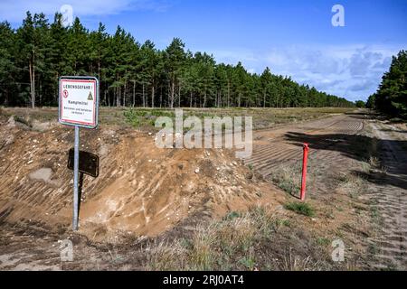 Neuglienicke, Deutschland. August 2023. Ein Schild weist auf das Gebiet in Kyritz-Ruppiner Heide hin, in dem auf dem ehemaligen militärischen Trainingsgelände Sprengstoffabwürfe durchgeführt werden. Insbesondere die verbotene Streumunition wird im Ex-Bombodrom abgeräumt. Quelle: Jens Kalaene/dpa/Alamy Live News Stockfoto