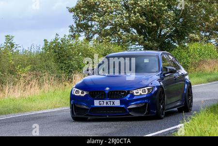 Woburn, Betten, Großbritannien - 19. August 2023: Blaues 2018 BMW M3 Auto auf einer englischen Landstraße. Stockfoto