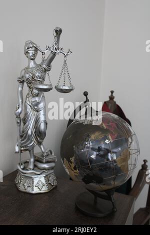 Transparente Weltkugel-Karte und Frauenstatue, die Gerechtigkeit und Recht symbolisiert. gerechtigkeit und Waage. Stockfoto