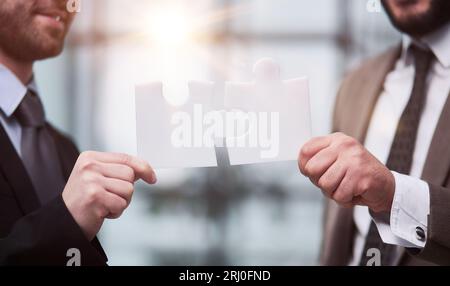 Partnerschaftskonzept mit Händen, die Puzzleteile zusammensetzen Stockfoto