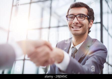 Junger Geschäftsmann, der seinem Partner die Hand schüttelt Stockfoto