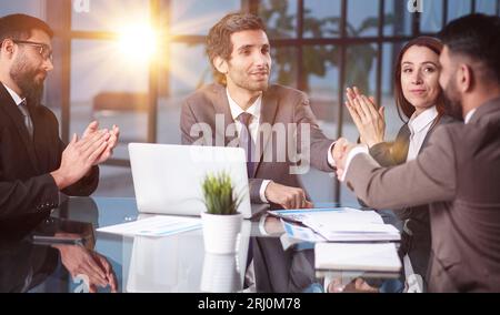 Ein junges Team von Kollegen, die in einem modernen Arbeitsbüro ein großartiges Geschäftsgespräch führen. Stockfoto